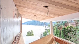 Cedar porch ceiling and wood railing overlooking water during construction